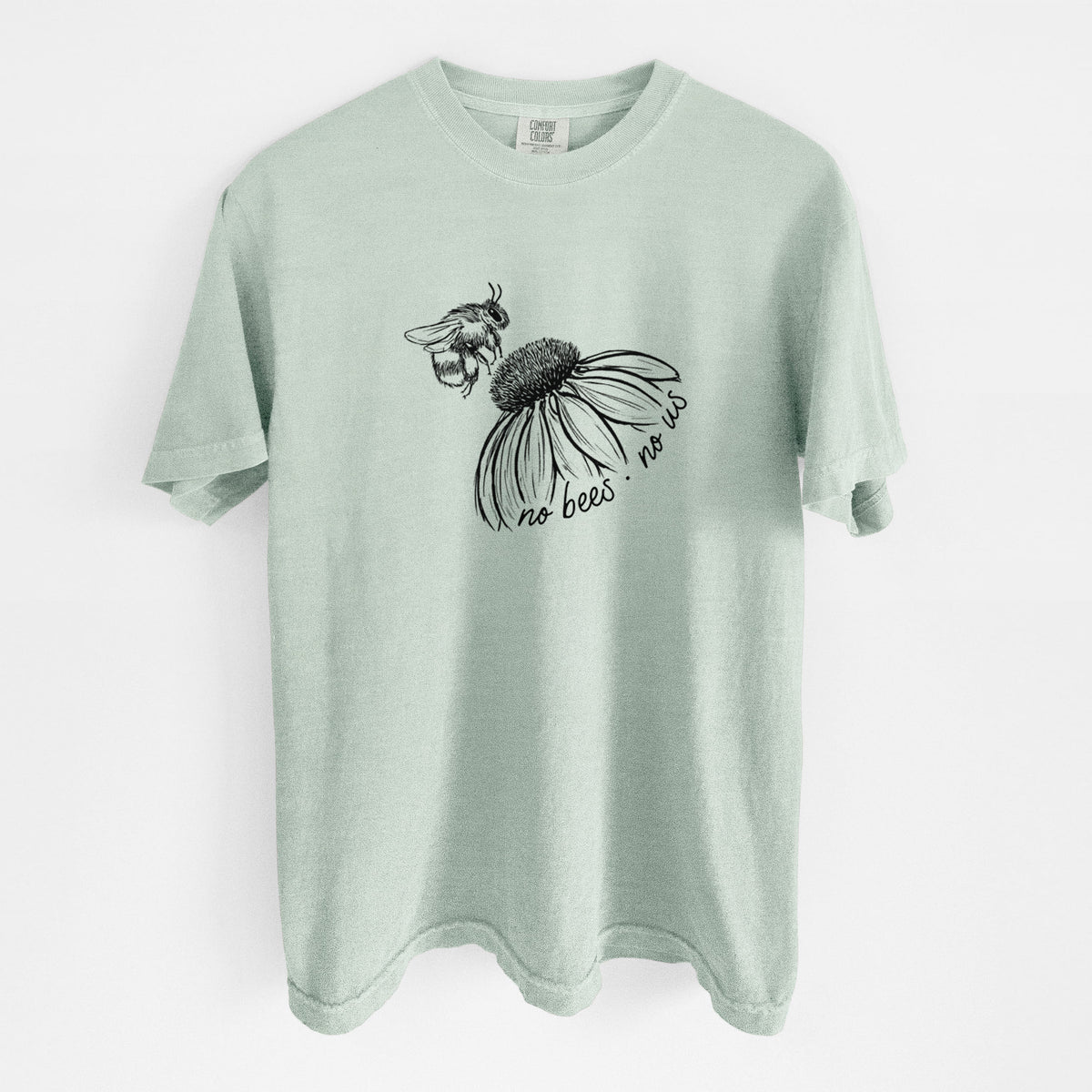 Bay green Comfort Colors t-shirt laid flat, printed with a black ink illustration of a bee flying toward a coneflower, with the handwritten words no bees no us.