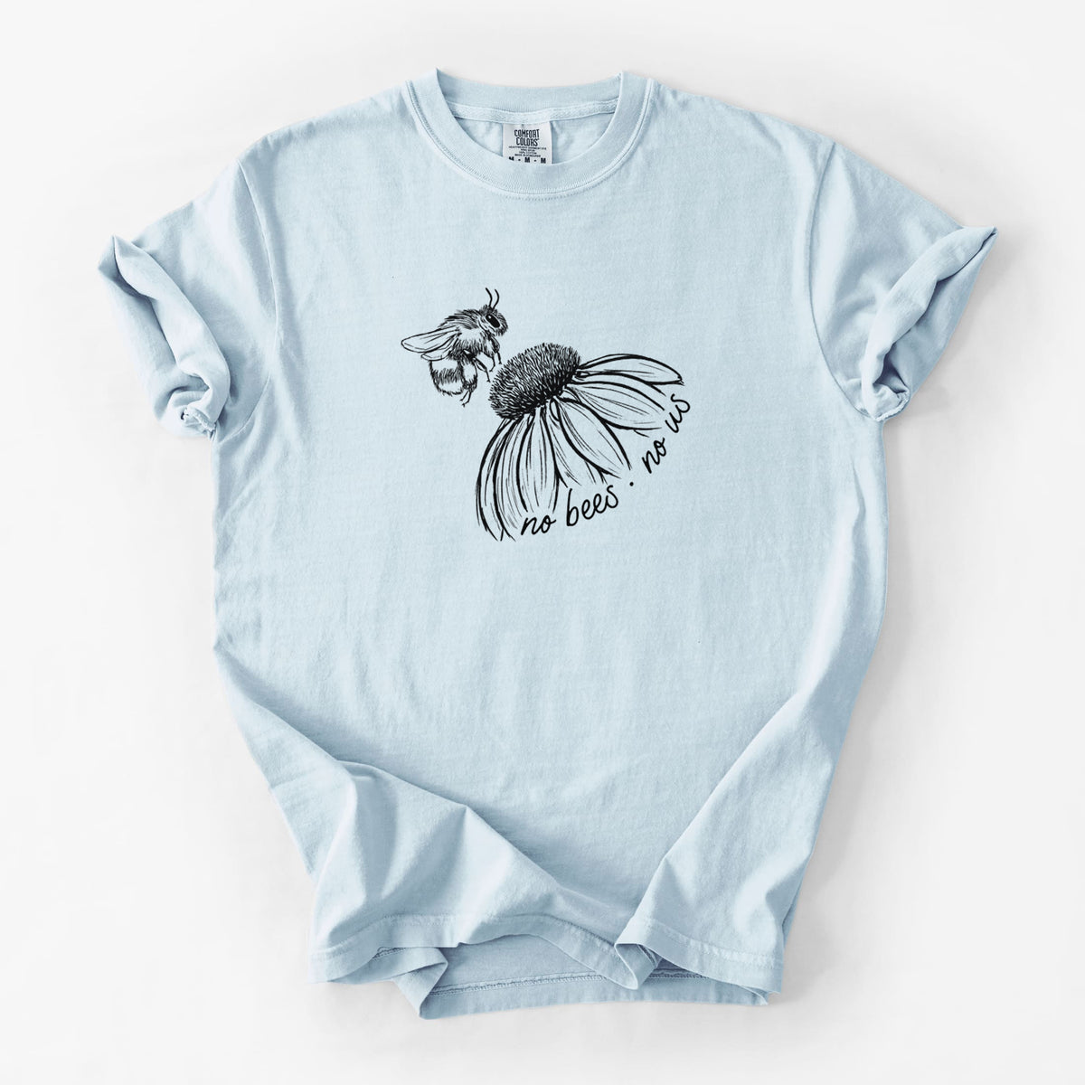 Chambray blue Comfort Colors t-shirt laid flat, printed with a black ink illustration of a bee flying toward a coneflower, with the handwritten words no bees no us.