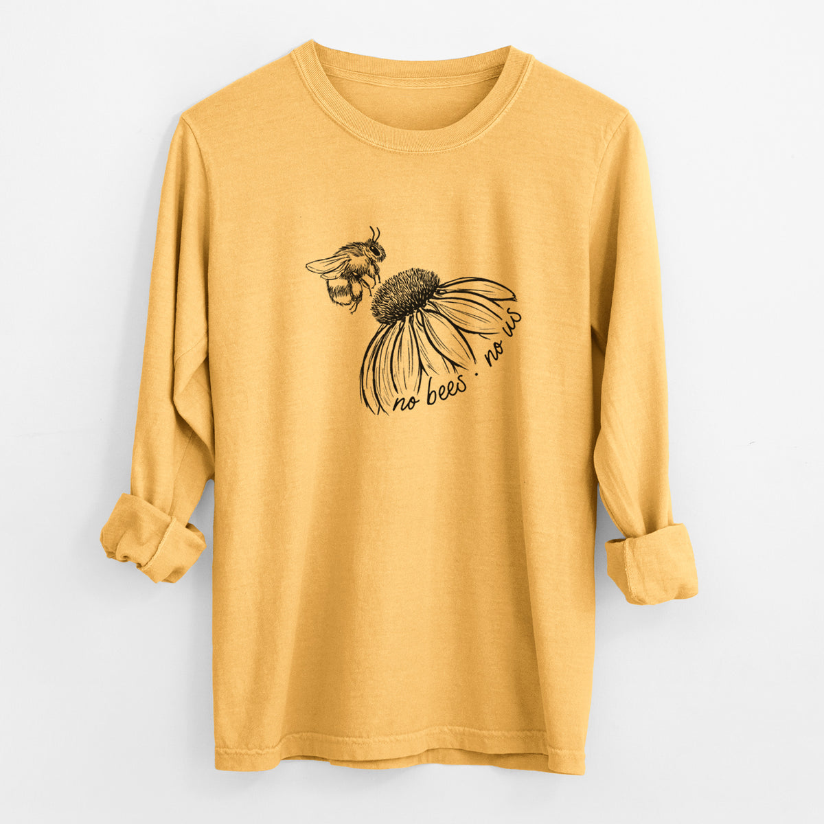 Golden wheat yellow Comfort Colors long sleeve shirt laid flat with the cuffs rolled, printed with a black ink illustration of a bee flying toward a coneflower, with the handwritten words no bees no us.