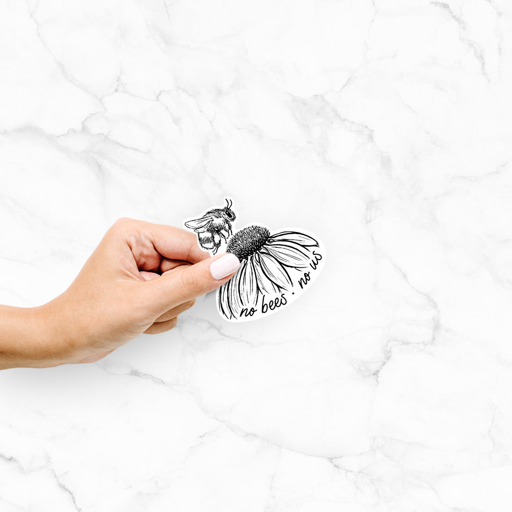 Hand holding a 4 inch vinyl decal of a black ink illustration of a bee flying toward a coneflower, with the handwritten words no bees no us.