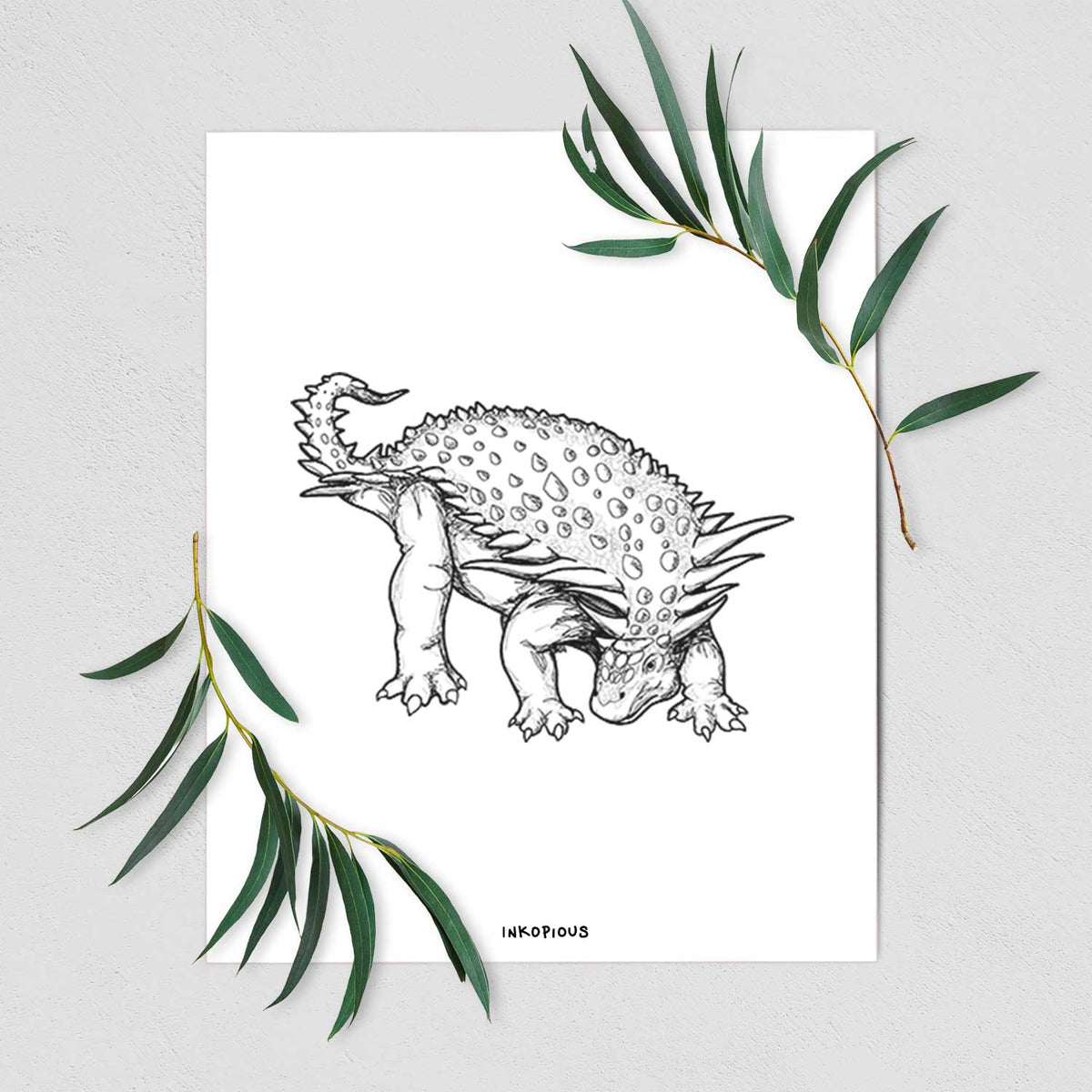 Art print of a black ink illustration of an armored Nodosaurus, shown with eucalyptus leaves.