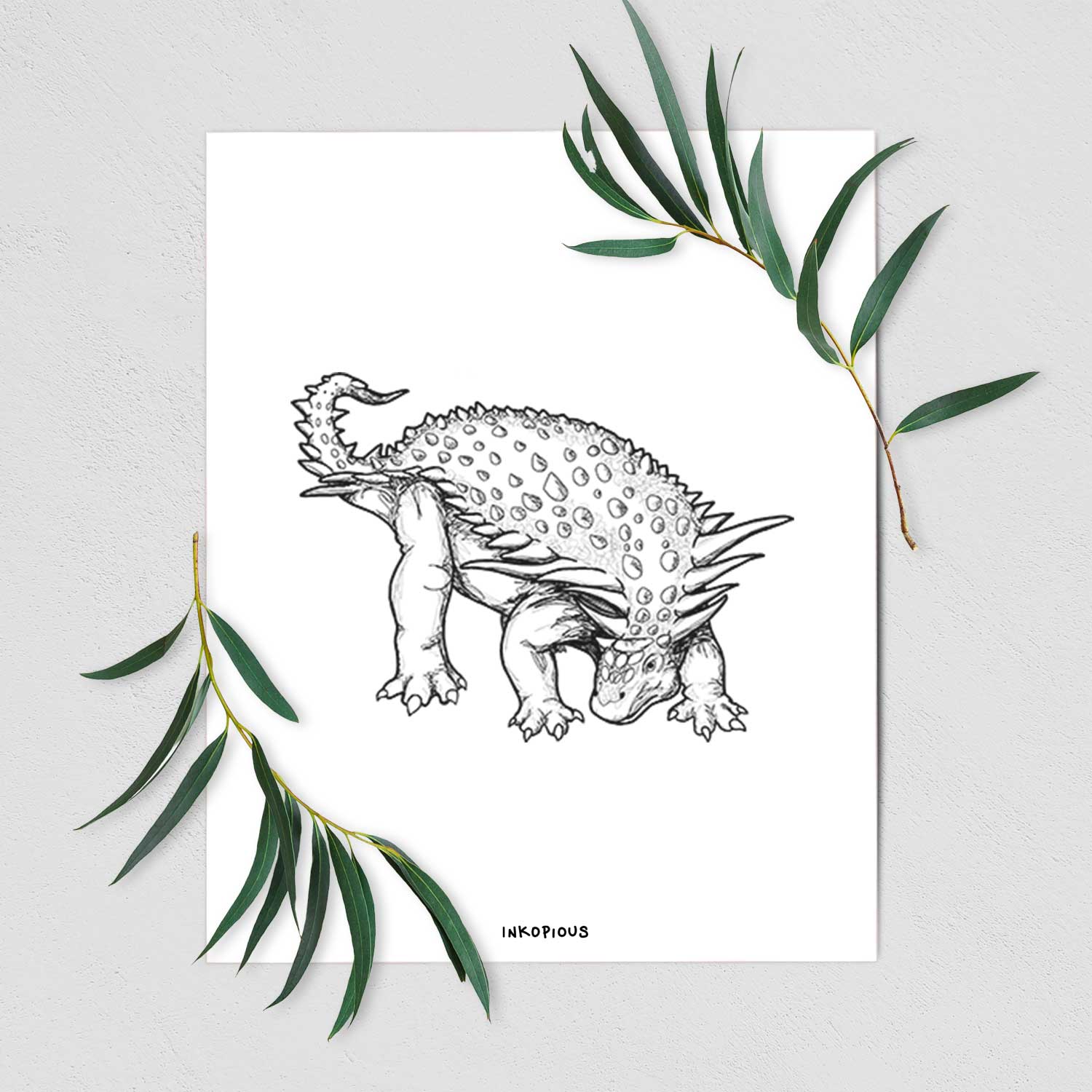 Art print of a black ink illustration of an armored Nodosaurus, shown with eucalyptus leaves.