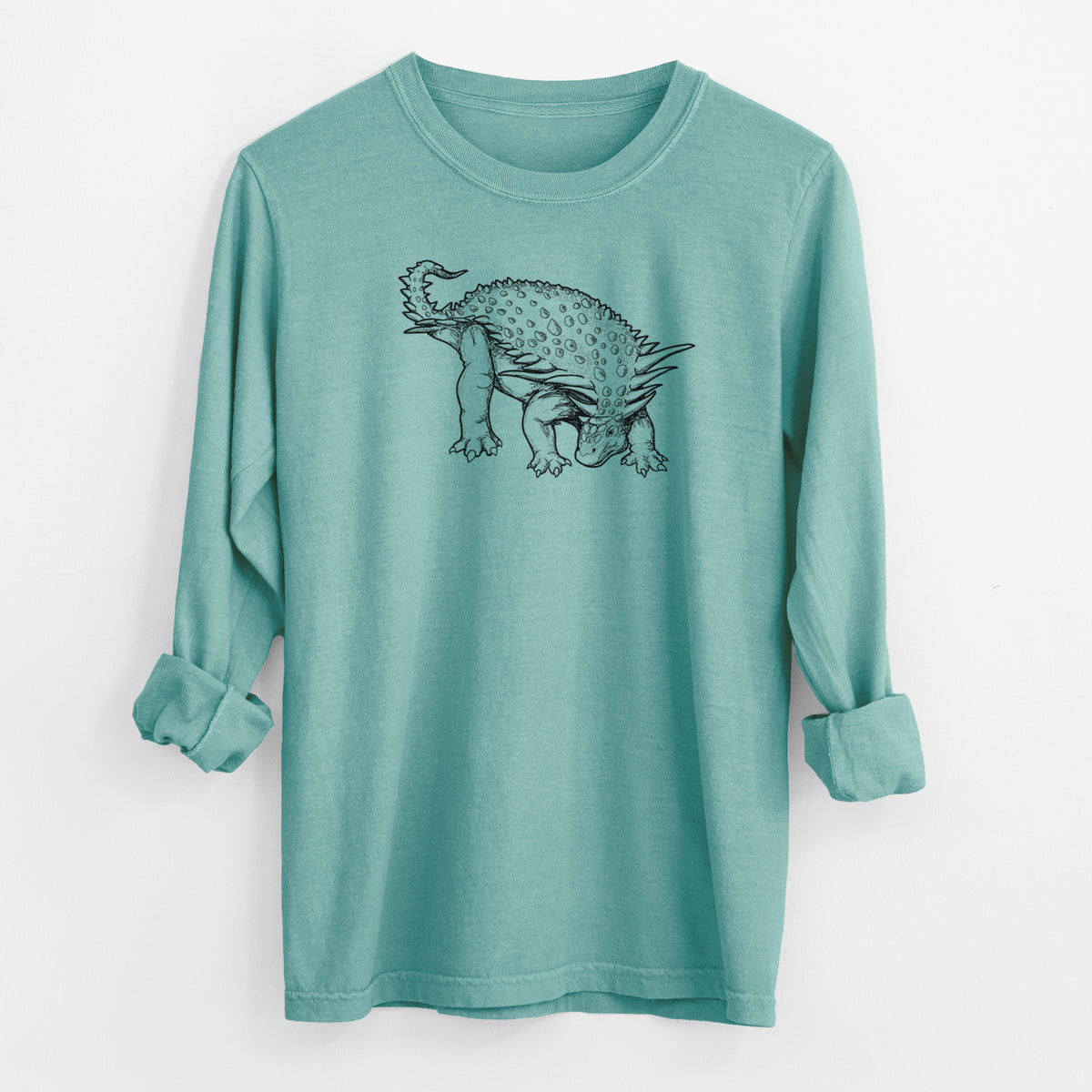 Reef green Comfort Colors long sleeve shirt laid flat with the cuffs rolled, printed with a black ink illustration of an armored Nodosaurus.
