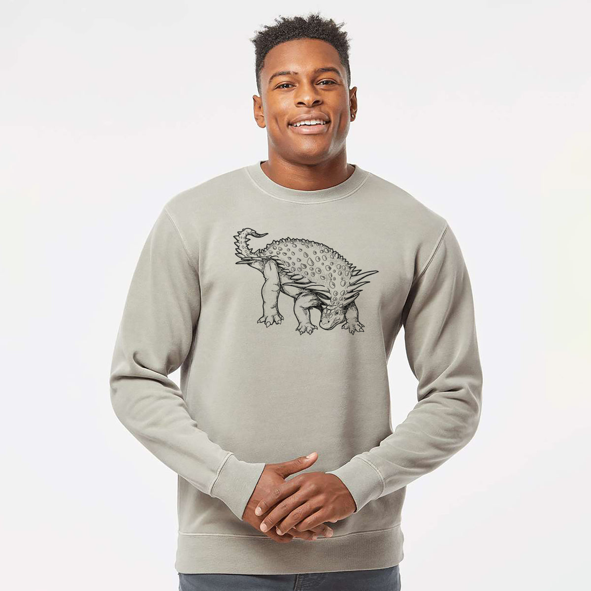 Model wearing a cement grey pigment dyed crewneck sweatshirt printed with a black ink illustration of an armored Nodosaurus.
