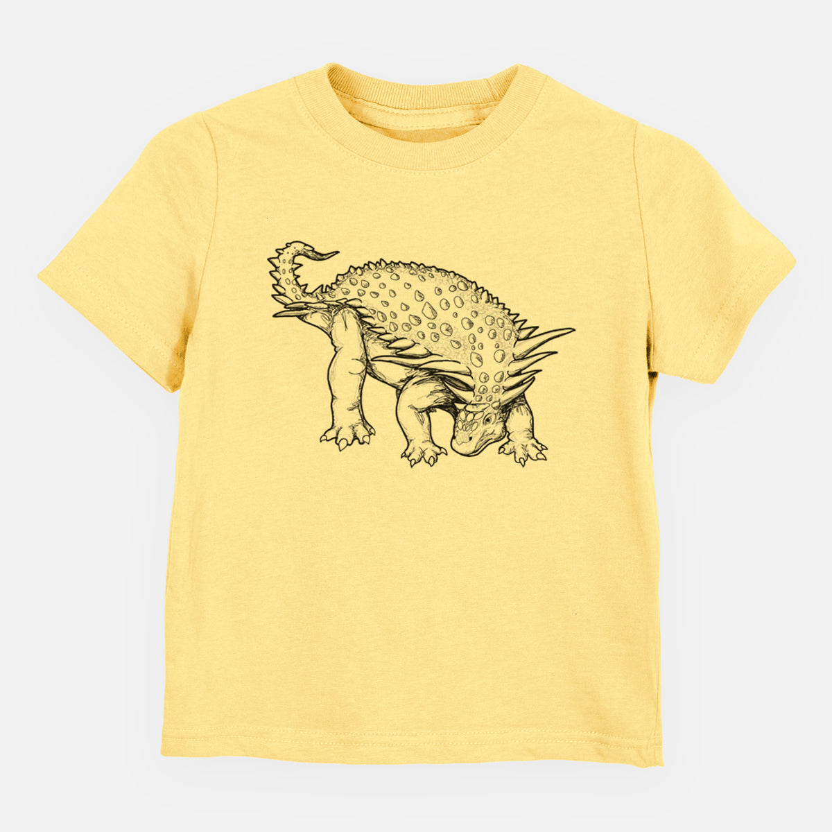 Butter yellow toddler t-shirt laid flat, printed with a black ink illustration of an armored Nodosaurus.