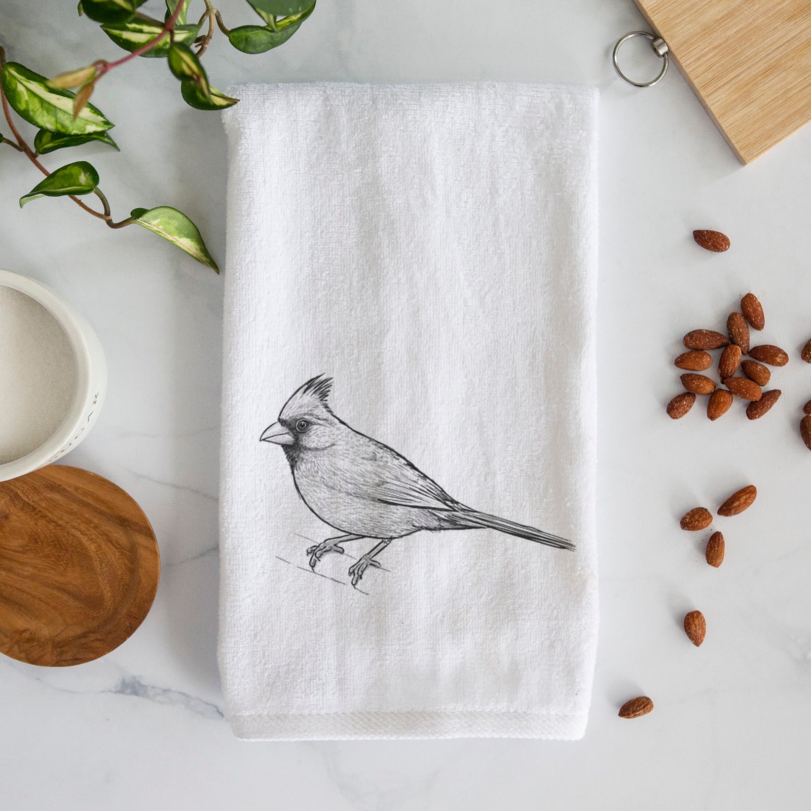 White hand towel printed with a detailed black ink sketch of a northern cardinal perched with its crest raised.