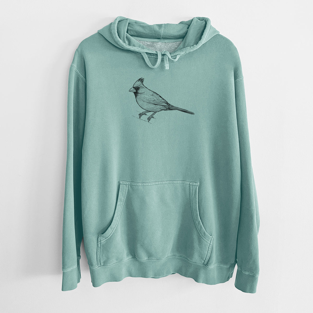 Mint green pigment dyed hoodie laid flat, printed with a detailed black ink sketch of a northern cardinal perched with its crest raised.