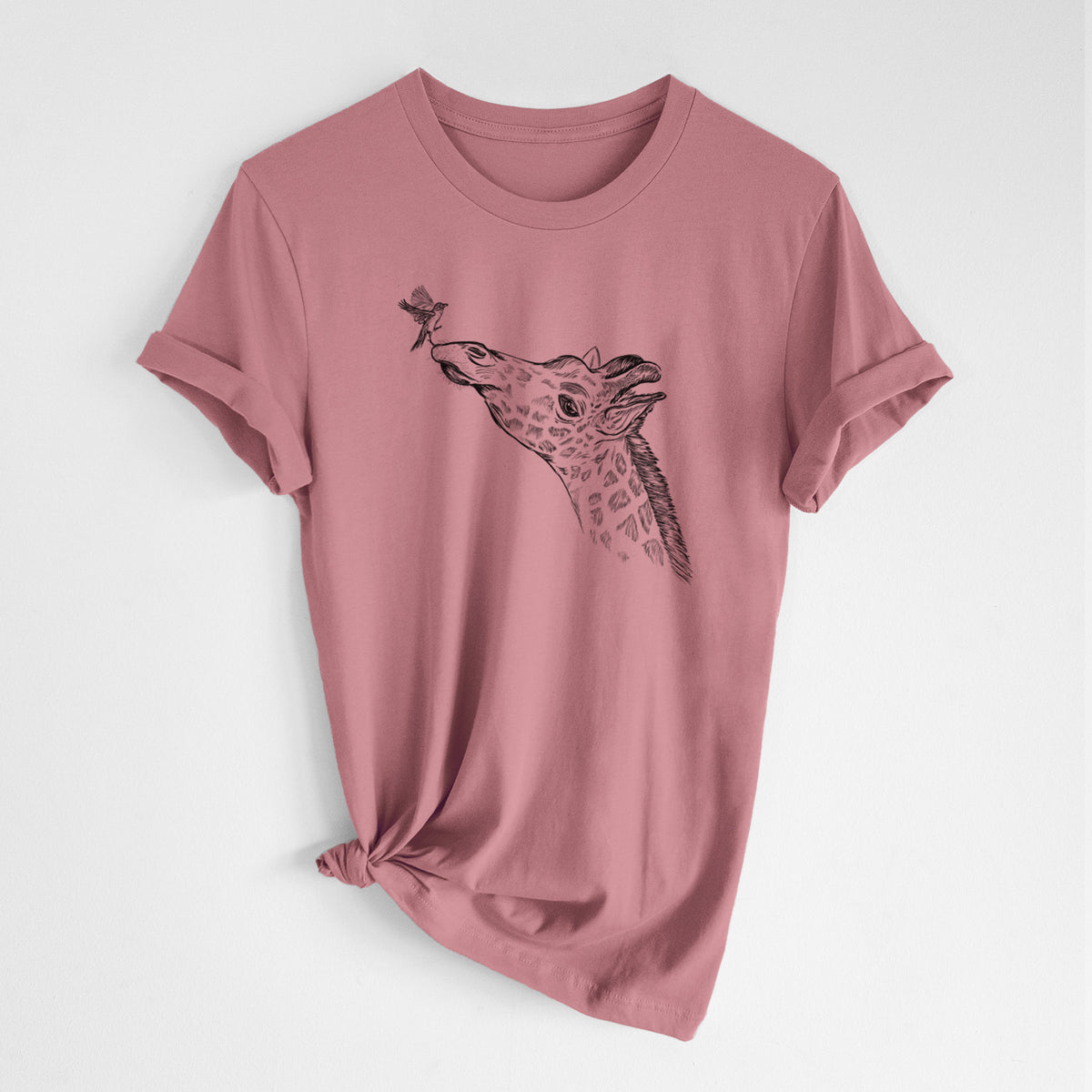 Mauve pink lightweight cotton t-shirt laid flat with the sleeves rolled, printed with a black ink illustration of a northern giraffe reaching its head up to nibble a flower.
