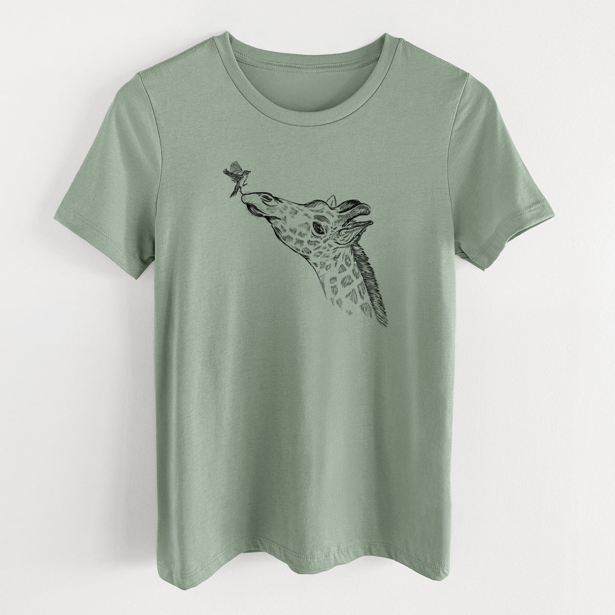 Sage green women's relaxed fit cotton t-shirt laid flat, printed with a black ink illustration of a northern giraffe reaching its head up to nibble a flower.