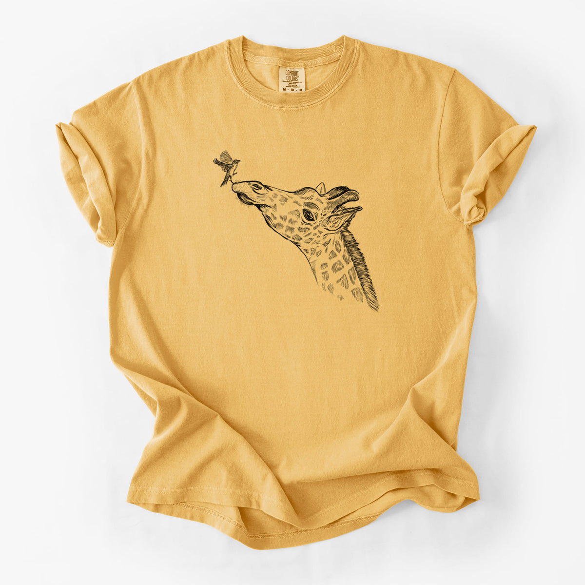 Golden wheat yellow Comfort Colors t-shirt laid flat, printed with a black ink illustration of a northern giraffe reaching its head up to nibble a flower.