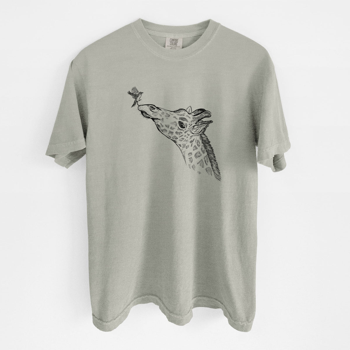 Sandstone beige Comfort Colors t-shirt laid flat, printed with a black ink illustration of a northern giraffe reaching its head up to nibble a flower.