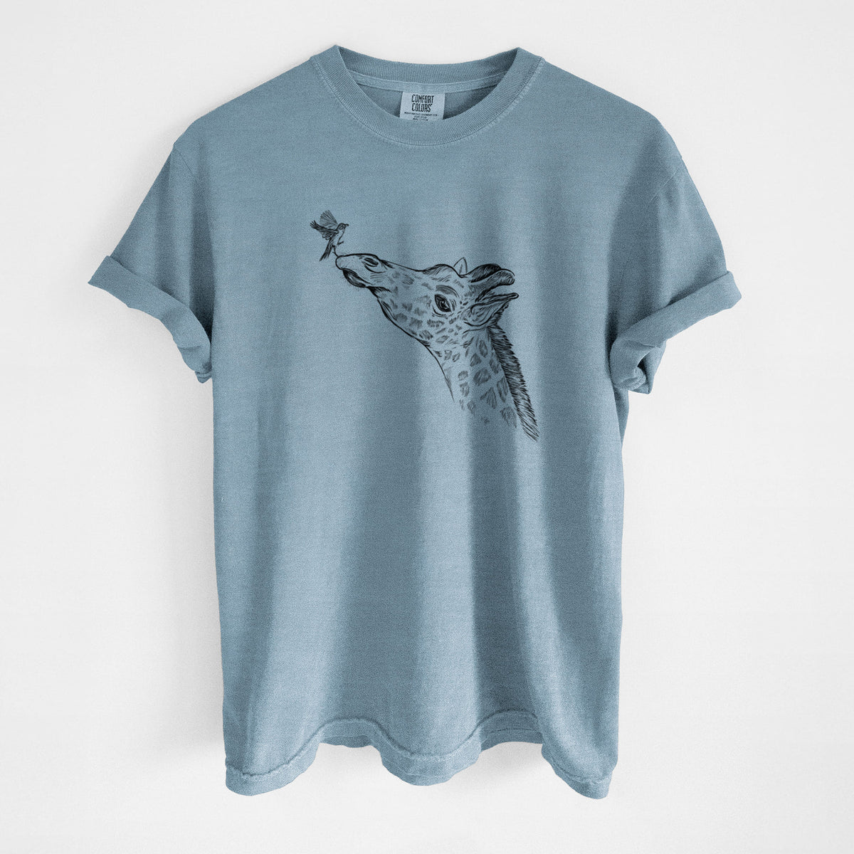 Steel blue Comfort Colors t-shirt laid flat, printed with a black ink illustration of a northern giraffe reaching its head up to nibble a flower.