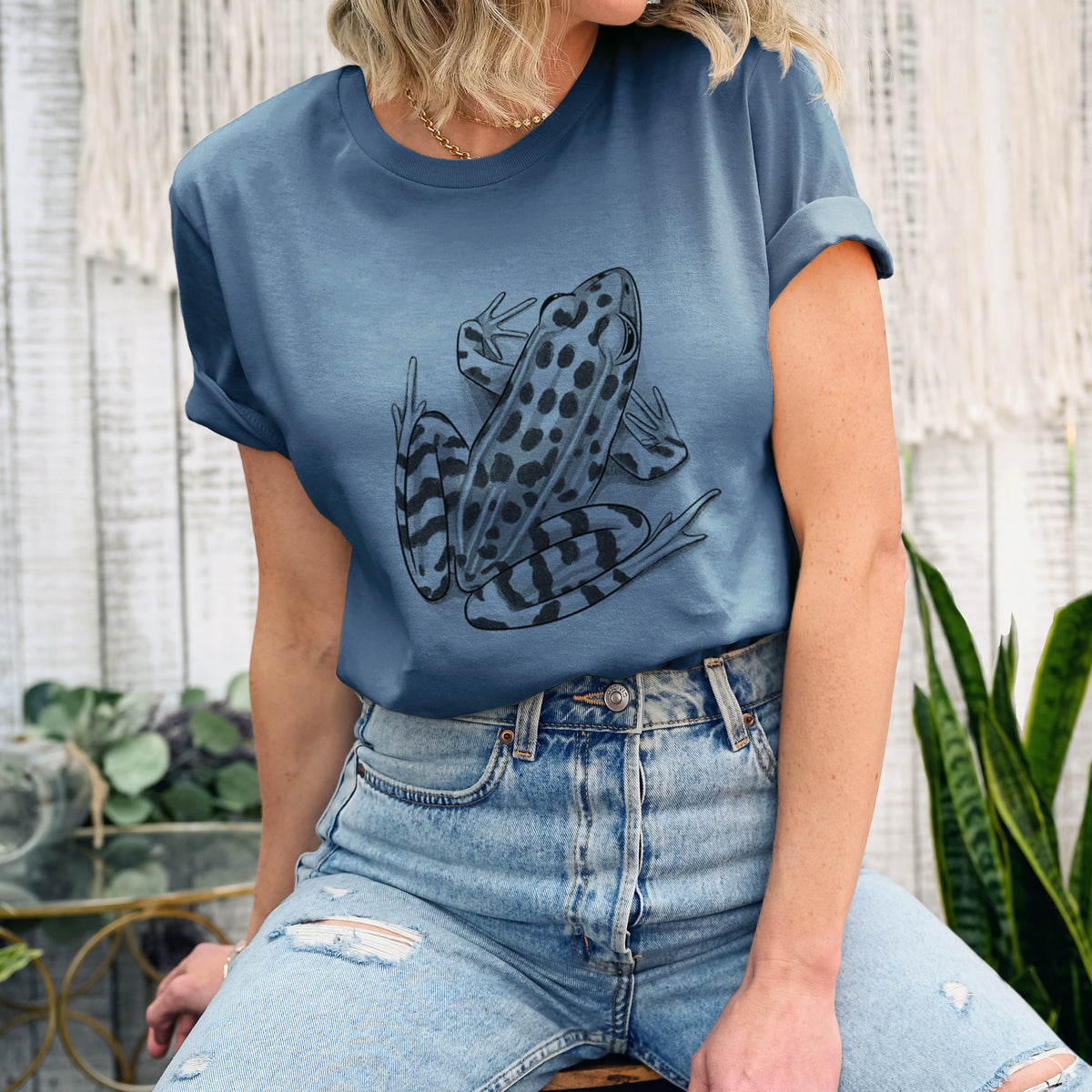 Woman wearing a steel blue lightweight cotton t-shirt printed with a detailed black ink illustration of a spotted northern leopard frog.