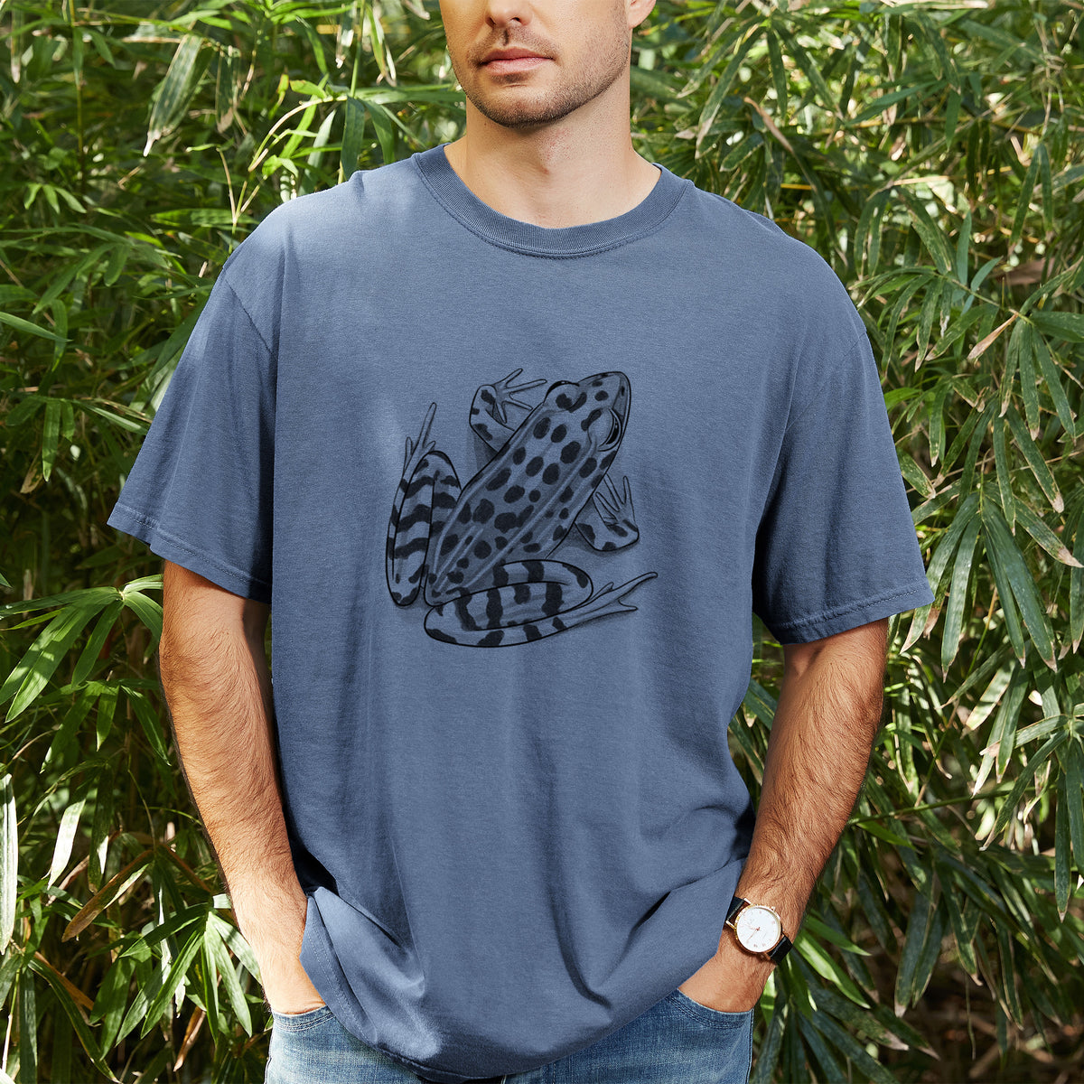 Man wearing a Comfort Colors t-shirt printed with a detailed black ink illustration of a spotted northern leopard frog, outdoors.