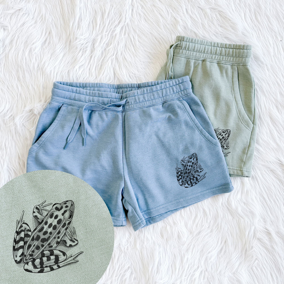 Two pairs of Cali Wave shorts in different colors printed with a detailed black ink illustration of a spotted northern leopard frog, with a close-up of the print.