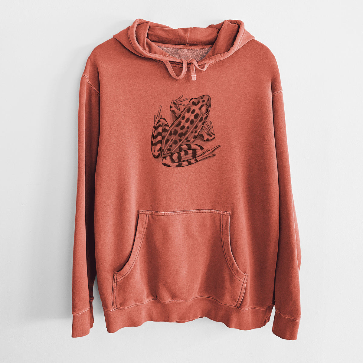 Amber orange pigment dyed hoodie laid flat, printed with a detailed black ink illustration of a spotted northern leopard frog.
