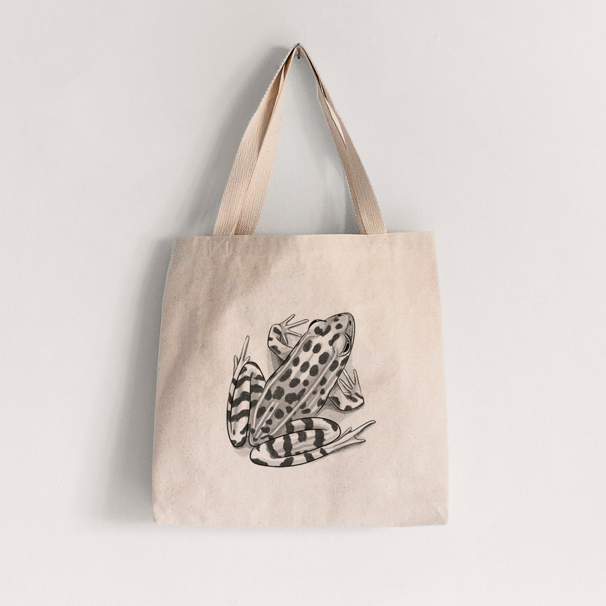 Natural canvas tote bag printed with a detailed black ink illustration of a spotted northern leopard frog.