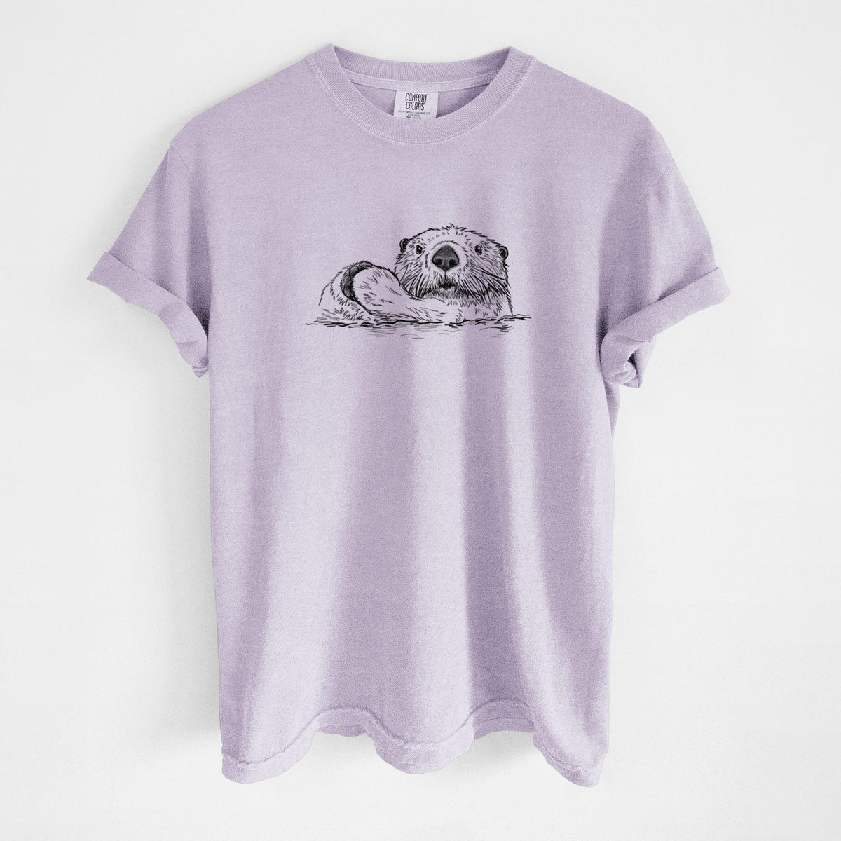 Orchid purple Comfort Colors t-shirt laid flat, printed with a black ink illustration of a northern river otter peeking out of the water.