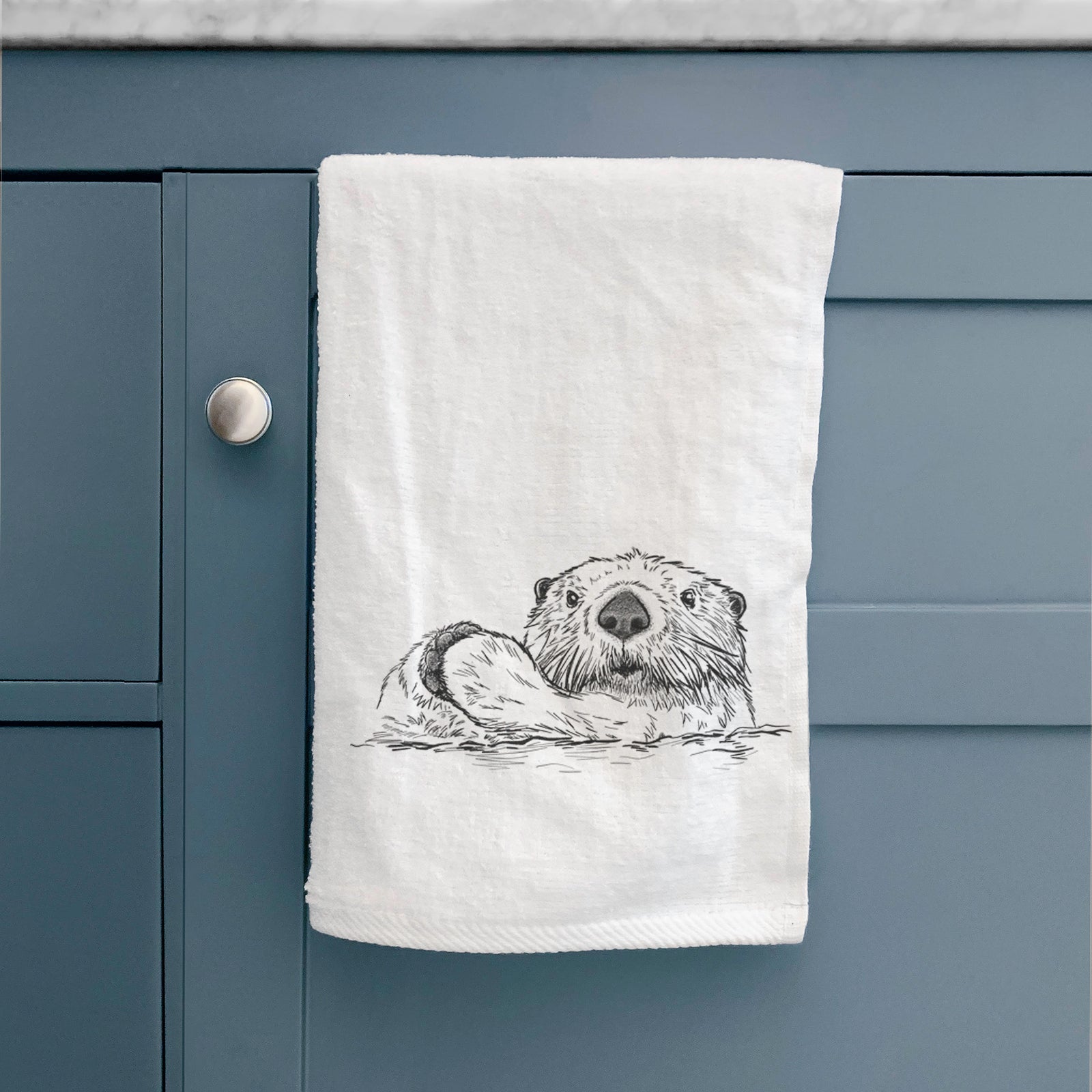 White hand towel printed with a black ink illustration of a northern river otter peeking out of the water.
