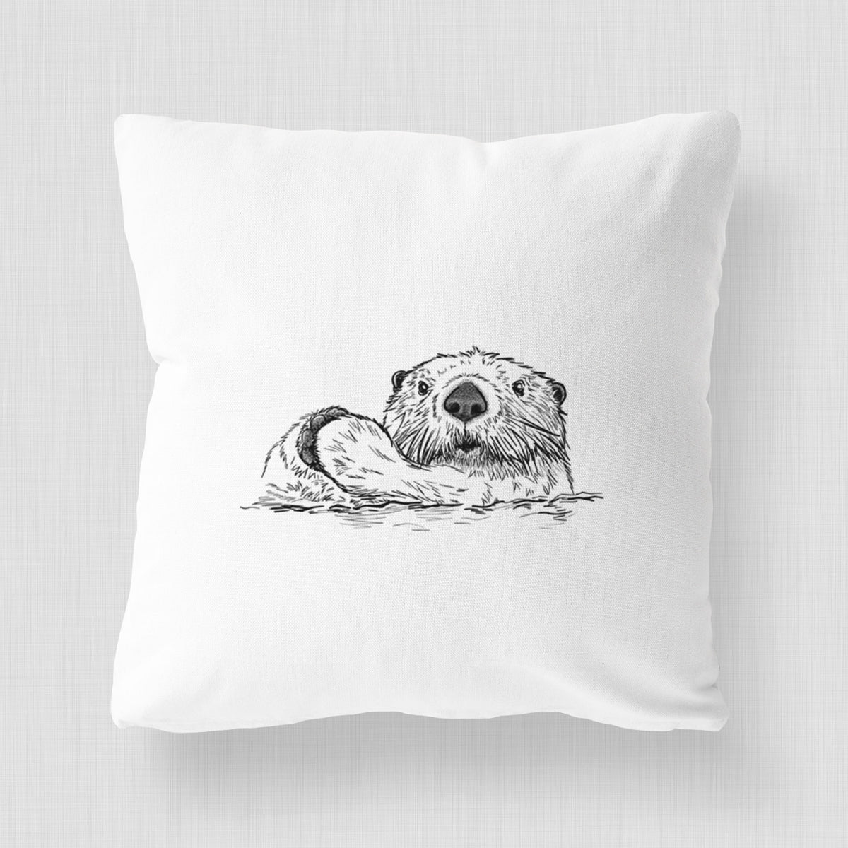 White pillow cover printed with a black ink illustration of a northern river otter peeking out of the water.