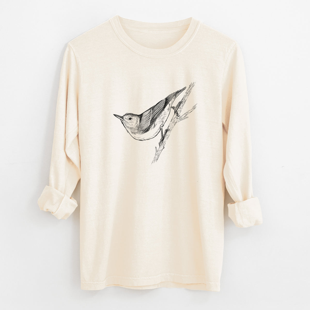 Ivory Comfort Colors long sleeve shirt laid flat with the cuffs rolled, printed with a detailed black ink sketch of a nuthatch clinging to a branch.