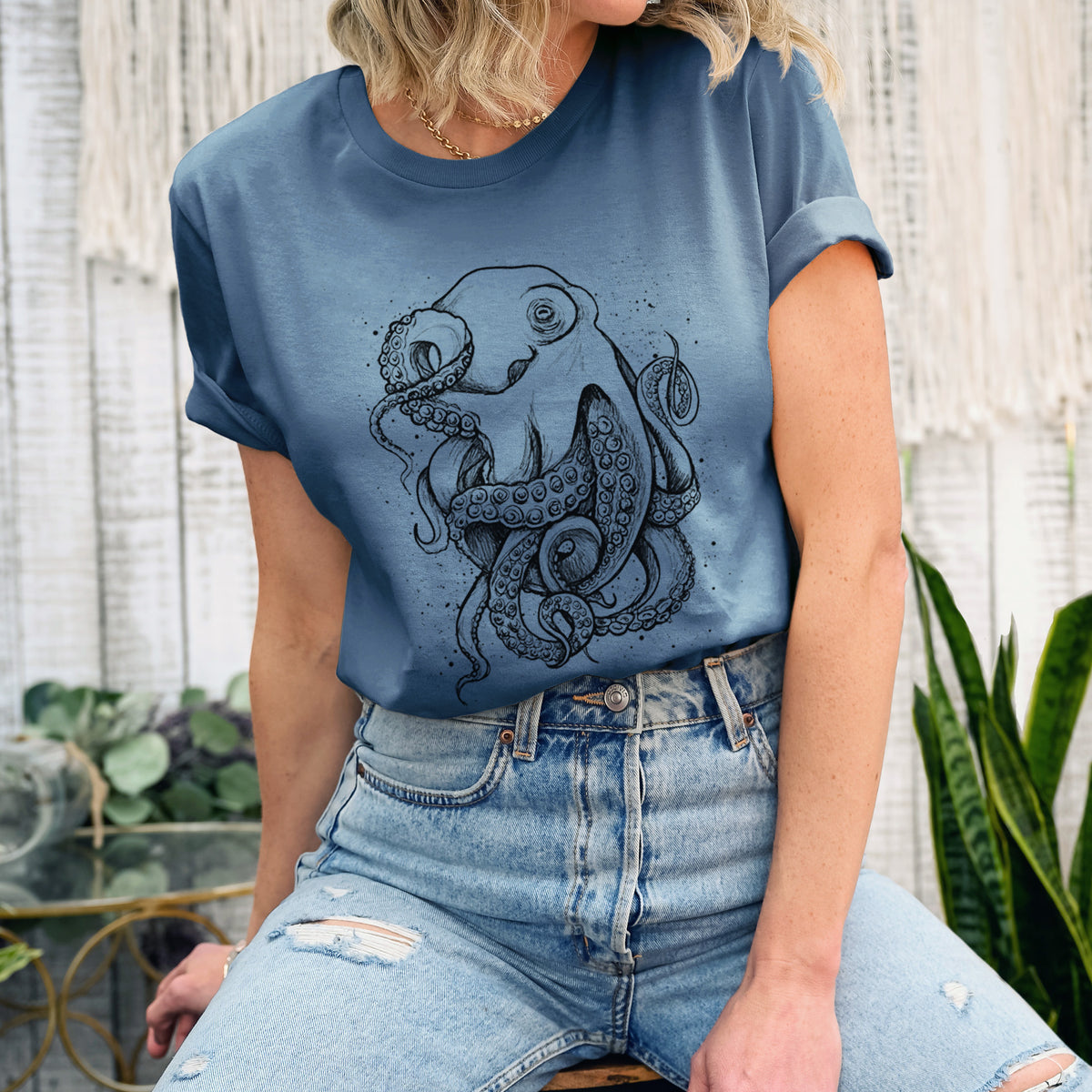 Woman wearing a steel blue lightweight cotton t-shirt printed with a detailed black ink illustration of a common octopus with curling tentacles.