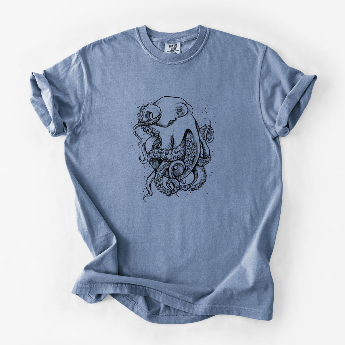 Blue jean Comfort Colors t-shirt laid flat, printed with a detailed black ink illustration of a common octopus with curling tentacles.
