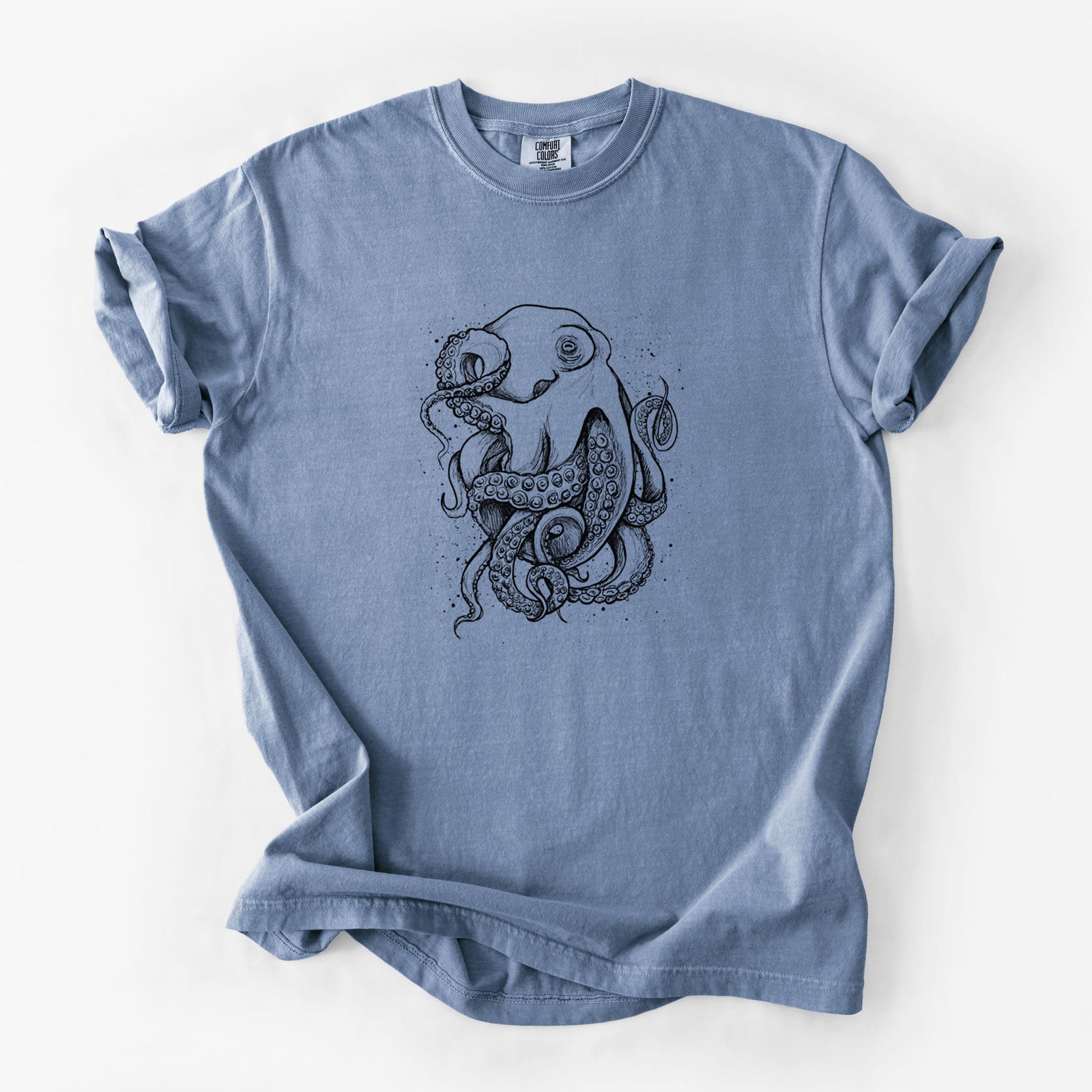 Steel blue Comfort Colors t-shirt laid flat, printed with a detailed black ink illustration of a common octopus with curling tentacles.