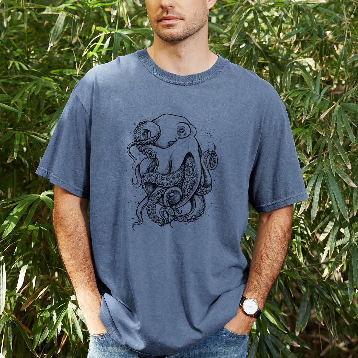 Man wearing a Comfort Colors t-shirt printed with a detailed black ink illustration of a common octopus with curling tentacles, outdoors.