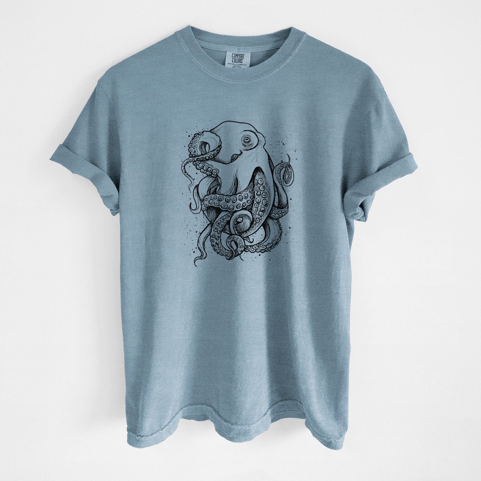 Steel blue Comfort Colors t-shirt laid flat, printed with a detailed black ink illustration of a common octopus with curling tentacles.