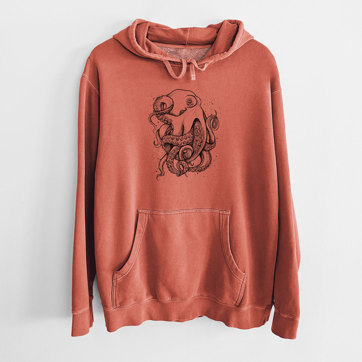 Amber orange pigment dyed hoodie laid flat, printed with a detailed black ink illustration of a common octopus with curling tentacles.