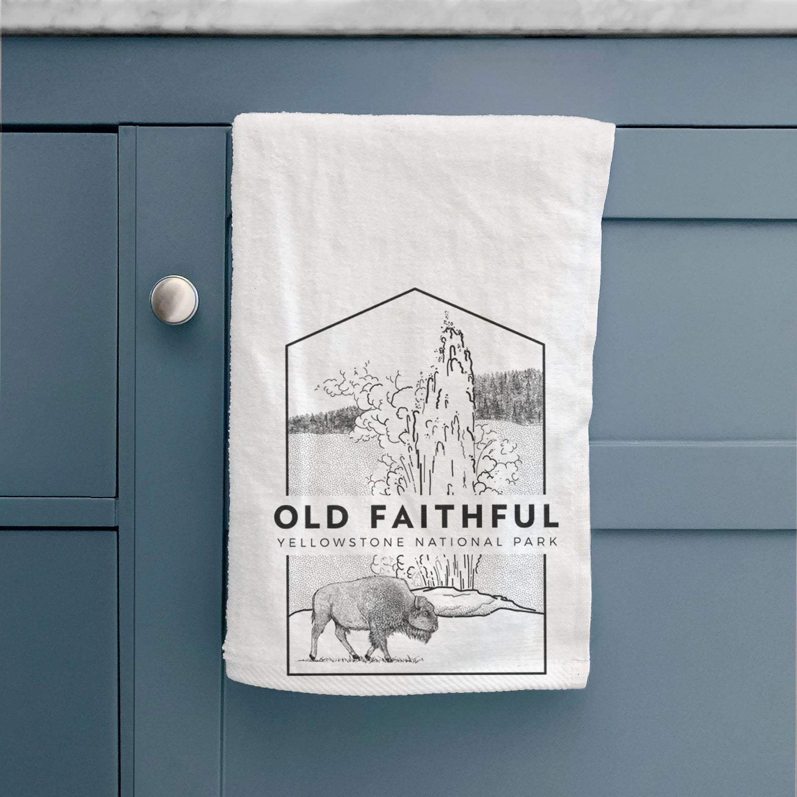 White hand towel printed with a black line art badge of the Old Faithful geyser erupting with a bison nearby, with the words Old Faithful, Yellowstone National Park.