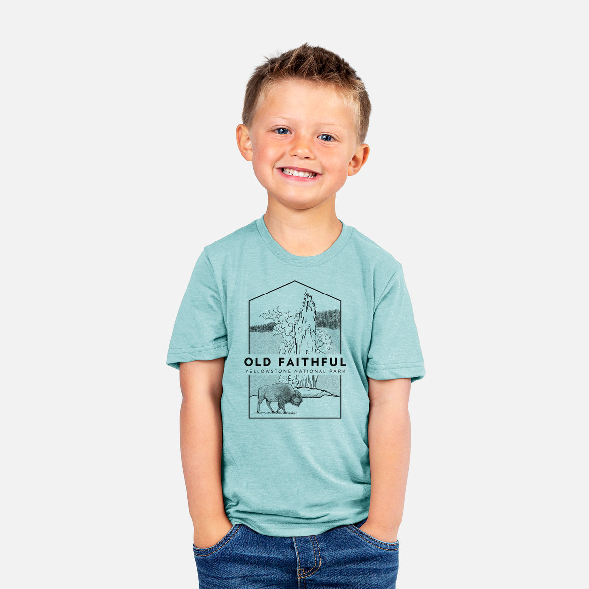 Smiling boy wearing a youth t-shirt printed with a black line art badge of the Old Faithful geyser erupting with a bison nearby, with the words Old Faithful, Yellowstone National Park.
