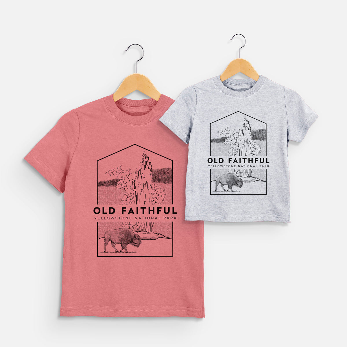 Two youth t-shirts in different colors on hangers, printed with a black line art badge of the Old Faithful geyser erupting with a bison nearby, with the words Old Faithful, Yellowstone National Park.