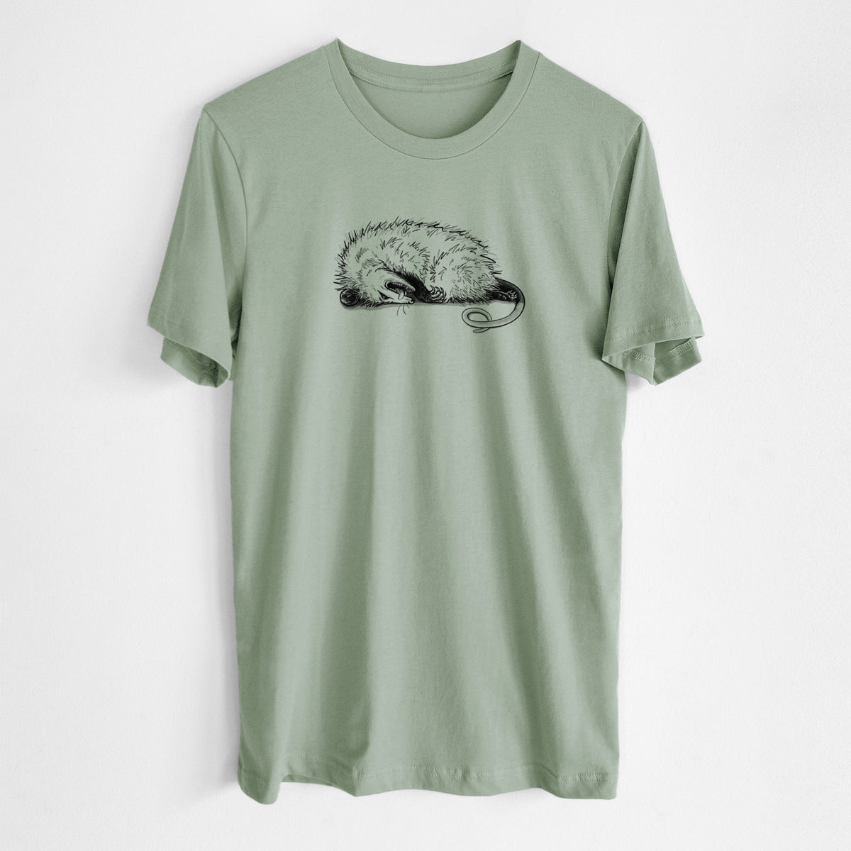 Sage green lightweight cotton t-shirt laid flat, printed with a black ink illustration of an opossum lying on its side playing dead.