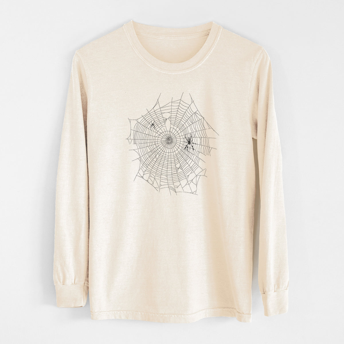 Ivory Comfort Colors long sleeve shirt laid flat, printed with a black ink line drawing of an orb weaver spider in the center of its web.