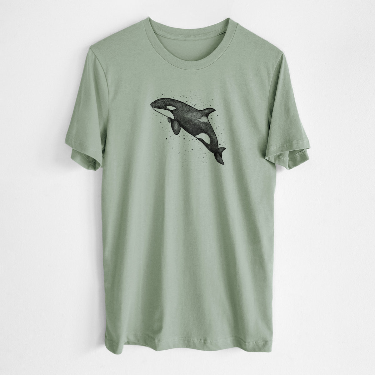Sage green lightweight cotton t-shirt laid flat, printed with a black ink illustration of an orca leaping, with ink splatters.
