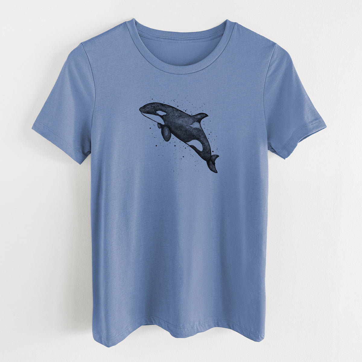 Blue bell women's relaxed fit cotton t-shirt laid flat, printed with a black ink illustration of an orca leaping, with ink splatters.
