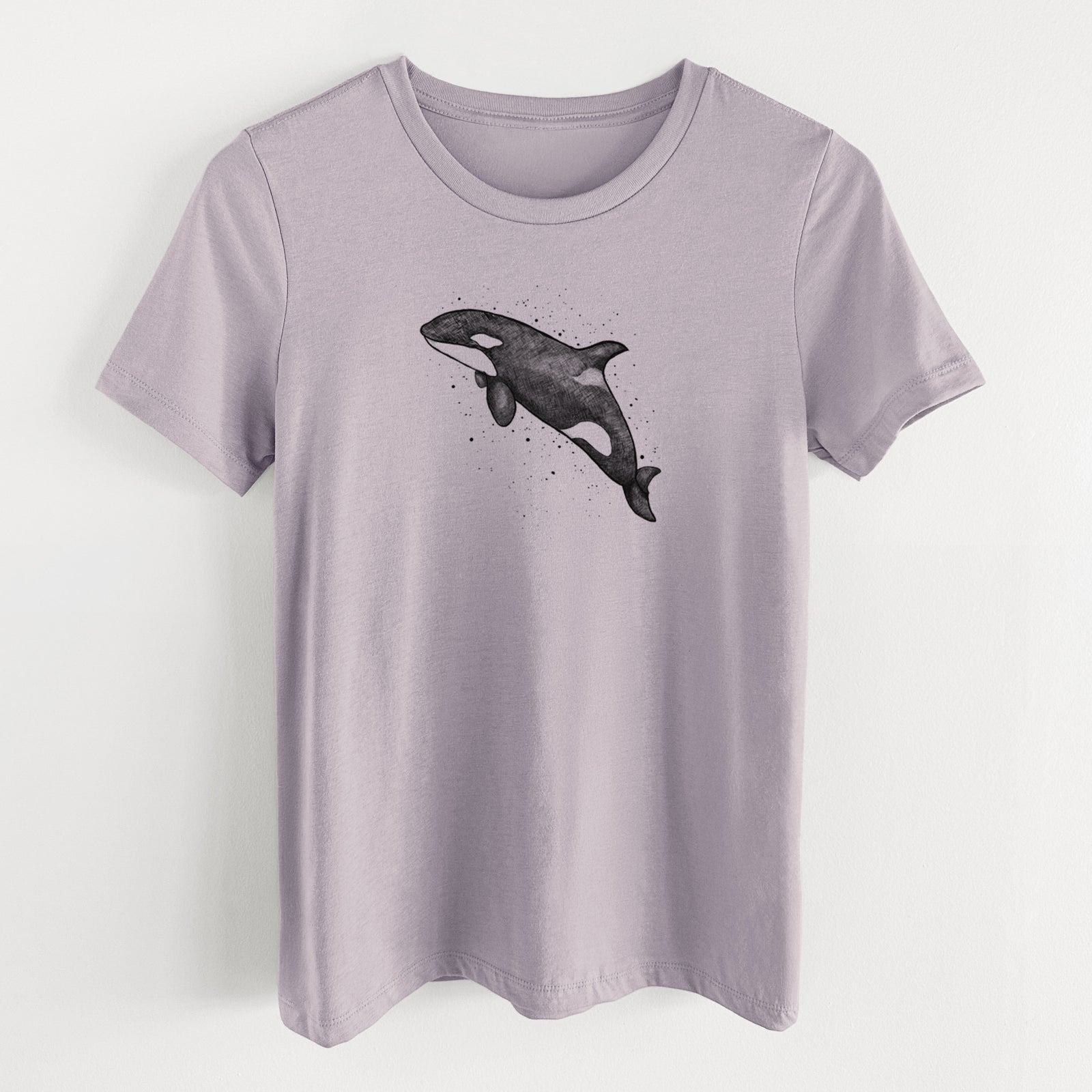 Light violet women's relaxed fit cotton t-shirt laid flat, printed with a black ink illustration of an orca leaping, with ink splatters.