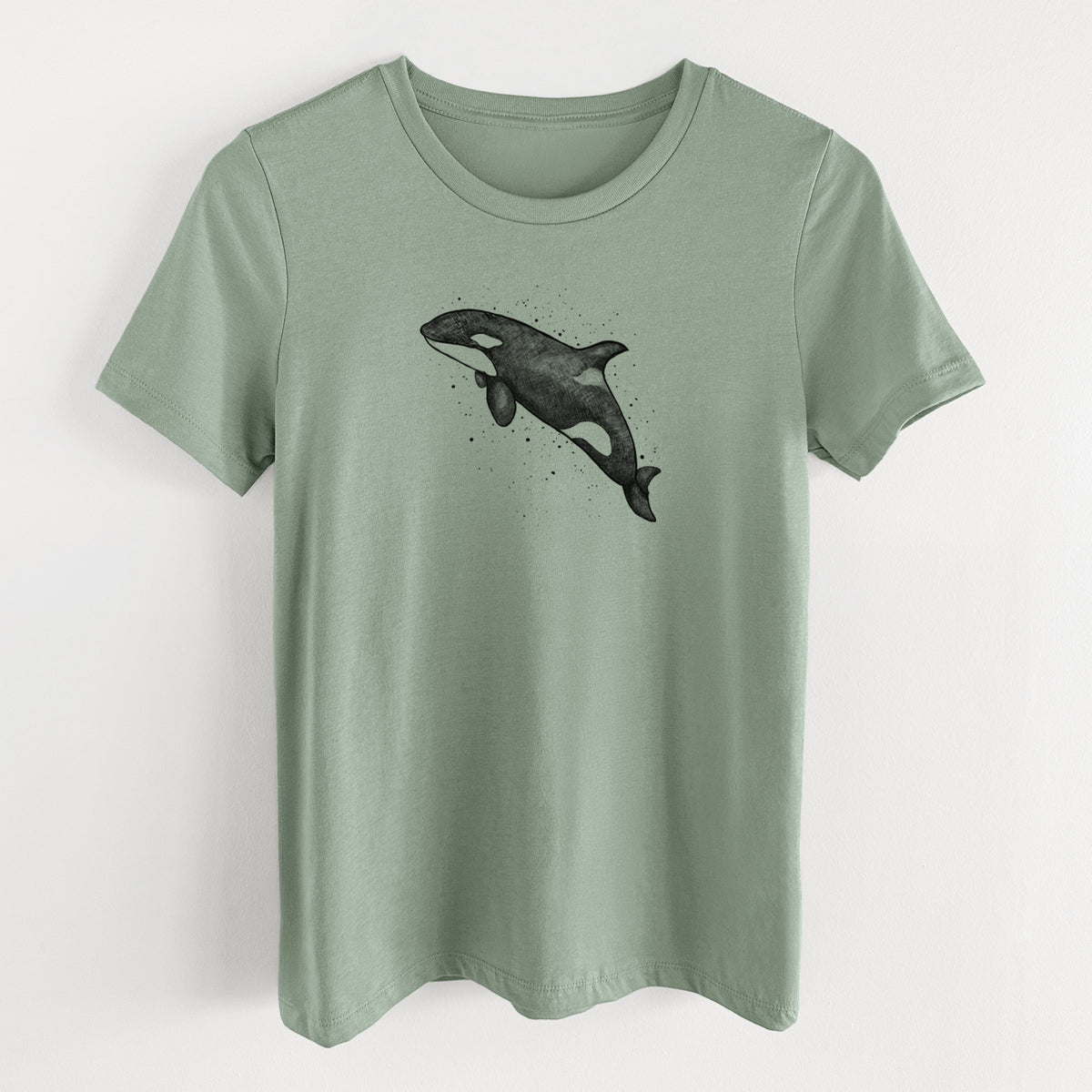 Sage green women's relaxed fit cotton t-shirt laid flat, printed with a black ink illustration of an orca leaping, with ink splatters.