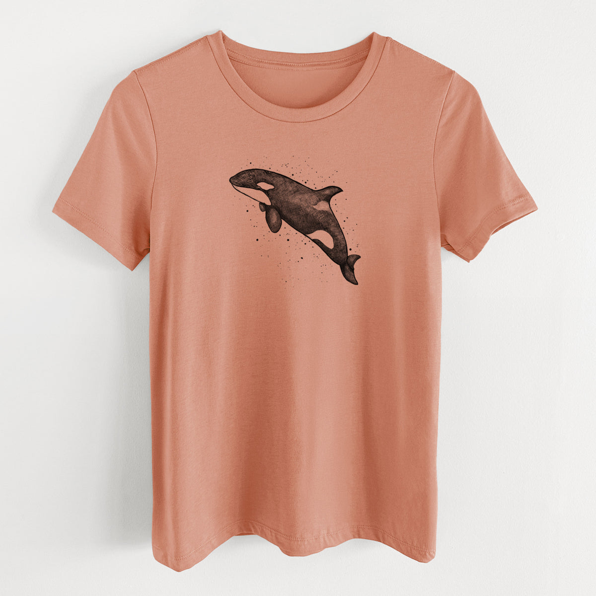 Terracotta orange women's relaxed fit cotton t-shirt laid flat, printed with a black ink illustration of an orca leaping, with ink splatters.