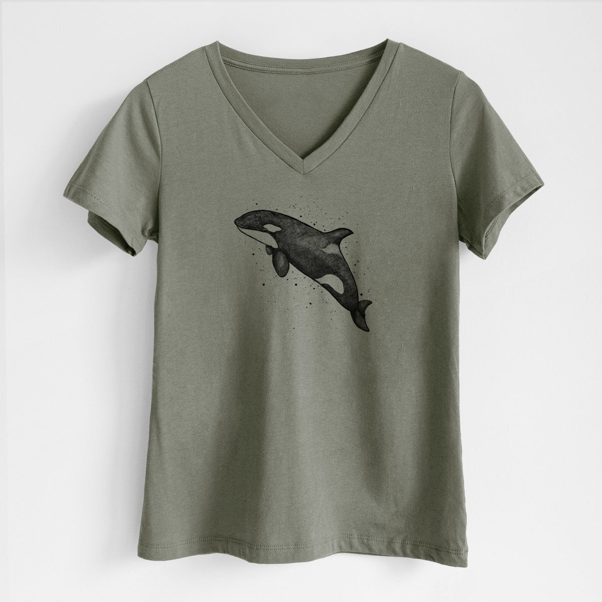 Military green women's relaxed fit cotton V-neck t-shirt laid flat, printed with a black ink illustration of an orca leaping, with ink splatters.