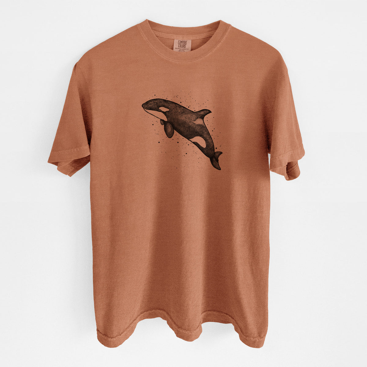 Yam burnt orange Comfort Colors t-shirt laid flat, printed with a black ink illustration of an orca leaping, with ink splatters.