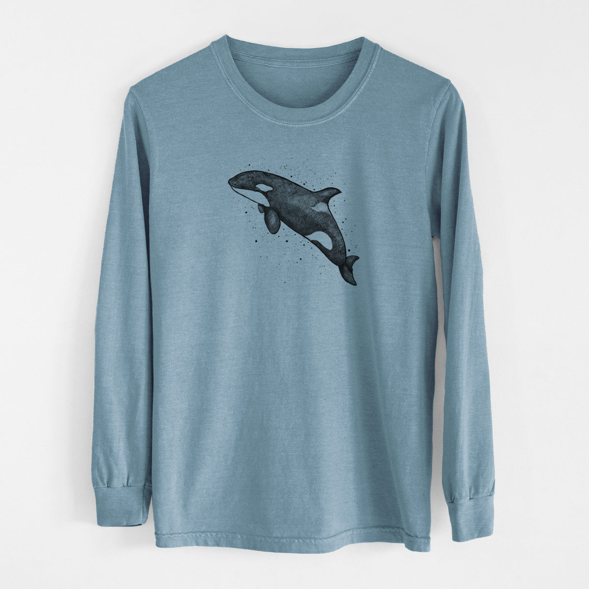 Steel blue Comfort Colors long sleeve shirt laid flat, printed with a black ink illustration of an orca leaping, with ink splatters.