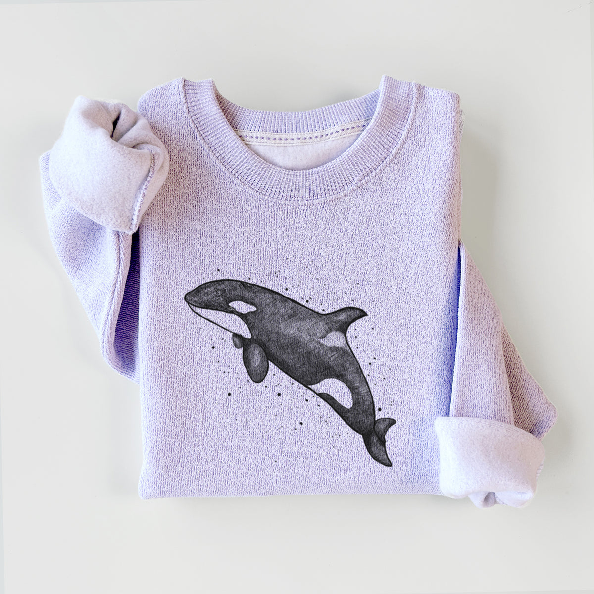 Ice purple knit sweatshirt printed with a black ink illustration of an orca leaping, with ink splatters, styled flat.