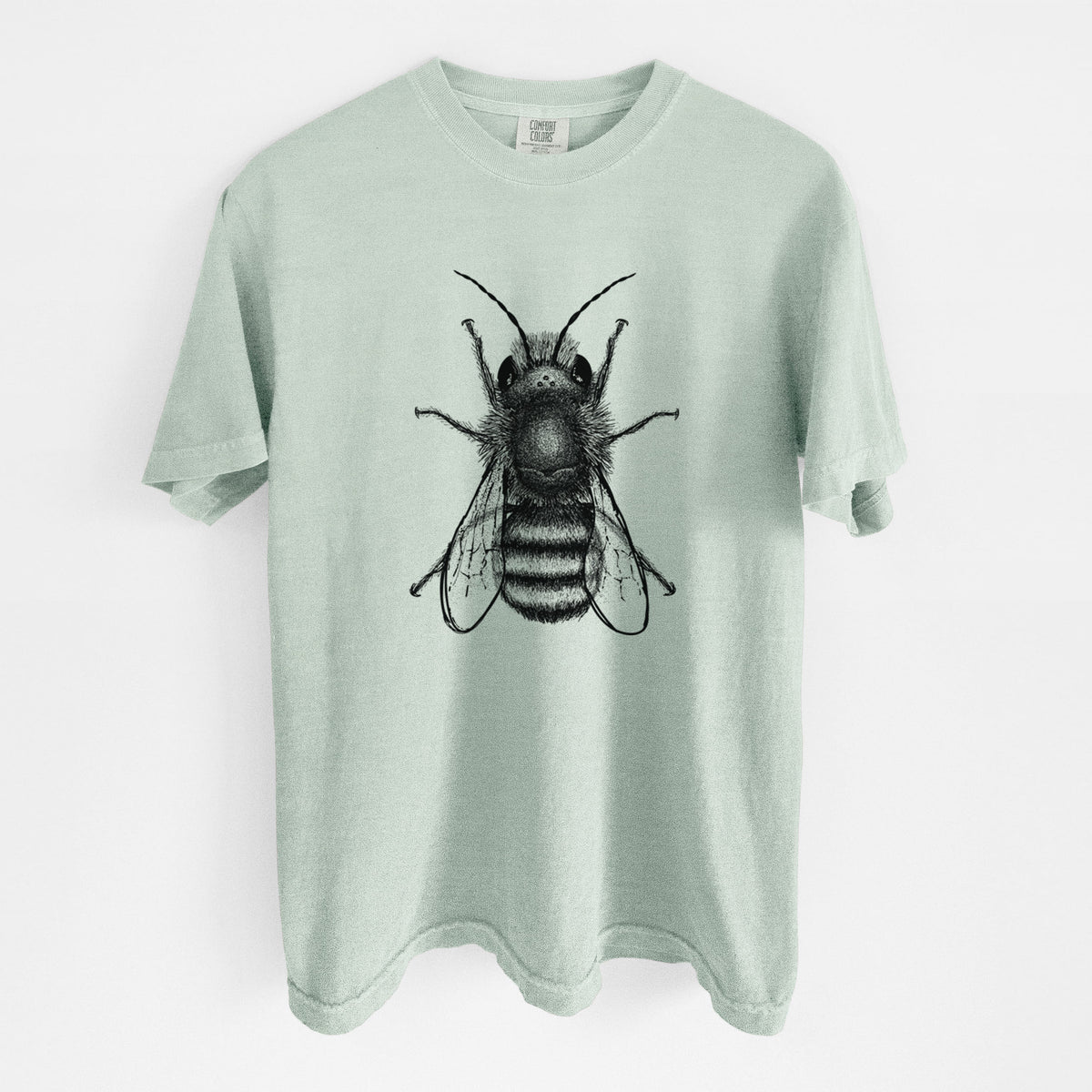 Bay green Comfort Colors t-shirt laid flat, printed with a detailed black ink illustration of a red mason bee with its wings spread, seen from above.