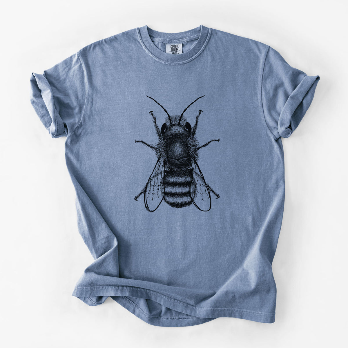 Blue jean Comfort Colors t-shirt laid flat, printed with a detailed black ink illustration of a red mason bee with its wings spread, seen from above.