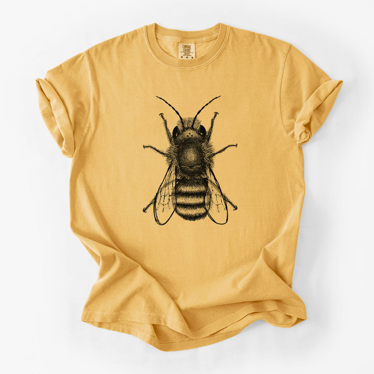 Golden wheat yellow Comfort Colors t-shirt laid flat, printed with a detailed black ink illustration of a red mason bee with its wings spread, seen from above.