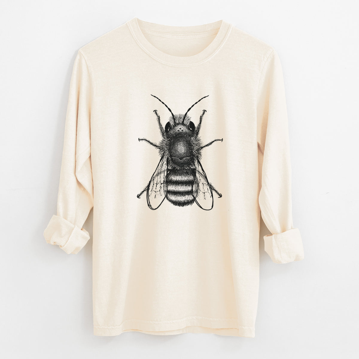 Ivory Comfort Colors long sleeve shirt laid flat with the cuffs rolled, printed with a detailed black ink illustration of a red mason bee with its wings spread, seen from above.