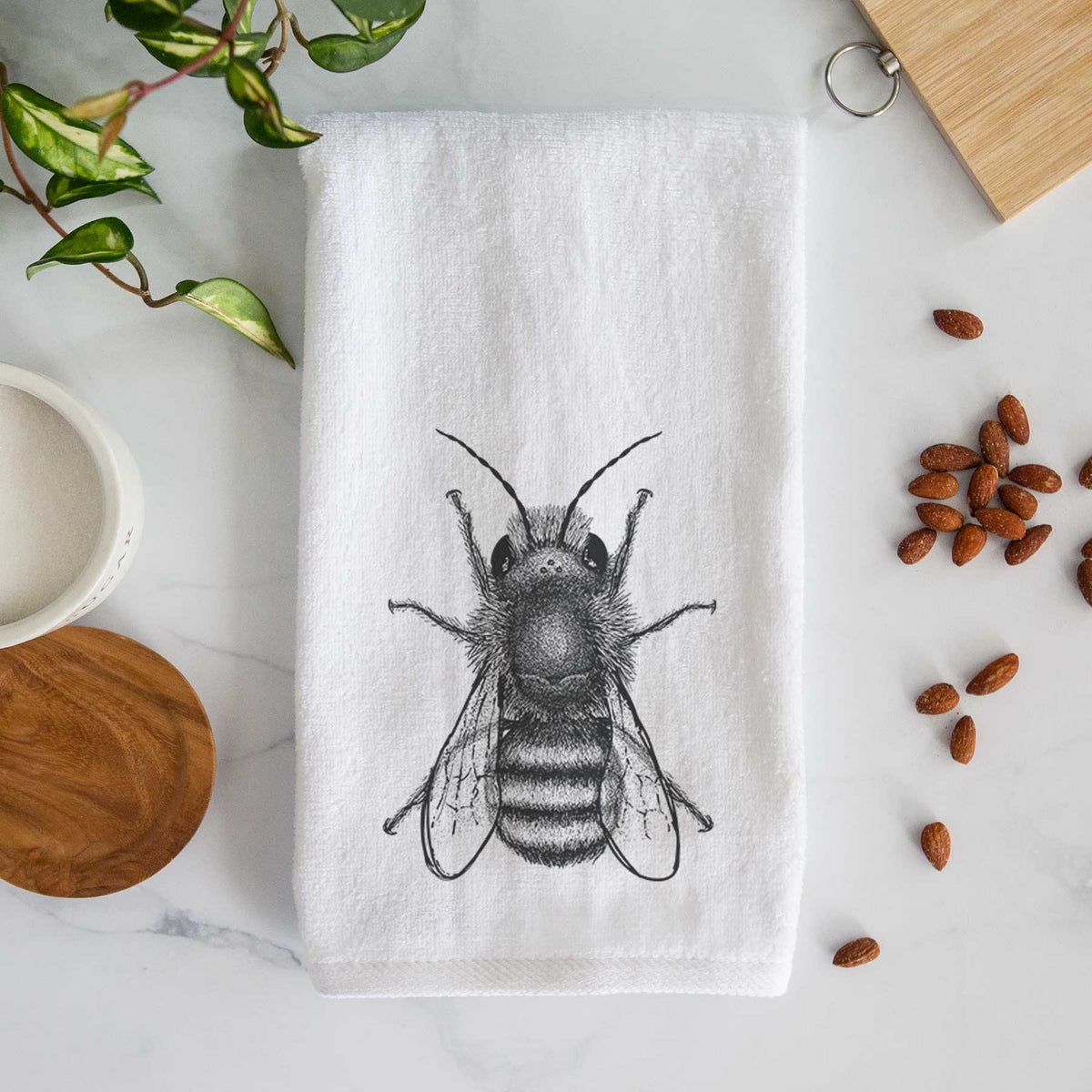White hand towel printed with a detailed black ink illustration of a red mason bee with its wings spread, seen from above.